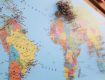 A close-up of a world map with colorful pins marking various locations.